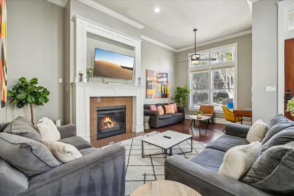 a living room with furniture fireplace and a large window
