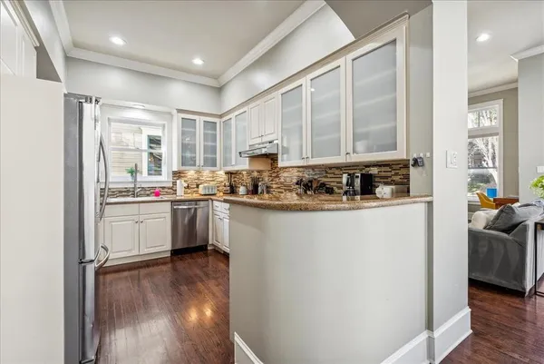 a kitchen with a refrigerator a sink and a stove top oven