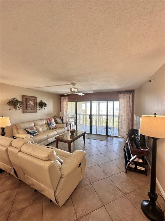 401 150th Avenue, Unit 266 Madeira Beach, FL 33708 - Photo 12 of 46 a living room with furniture a flat screen tv and a large window