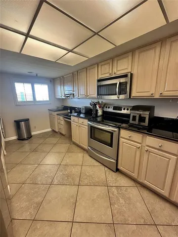 a kitchen with stainless steel appliances granite countertop a stove a sink a microwave and a refrigerator