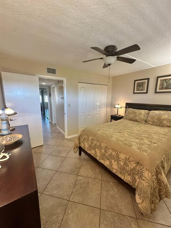 401 150th Avenue, Unit 266 Madeira Beach, FL 33708 - Photo 28 of 46 a spacious bedroom with a bed and a chandelier
