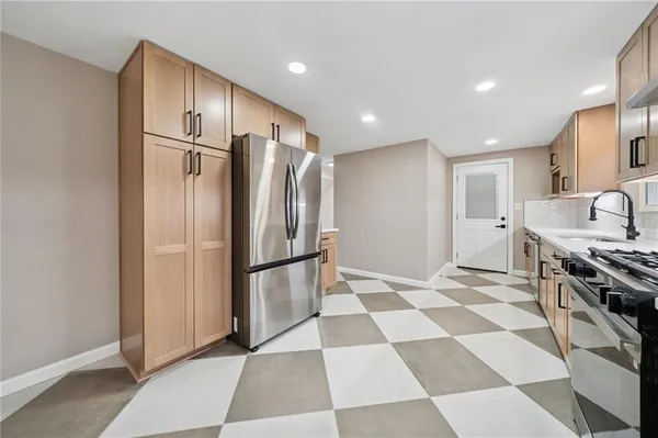 a kitchen with stainless steel appliances granite countertop a refrigerator and a stove top oven