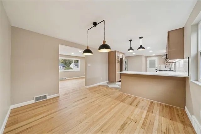 a view of a kitchen with wooden floor and a sink