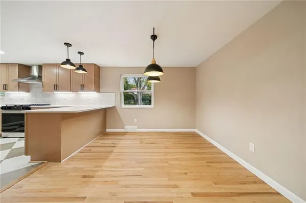a kitchen with kitchen island a counter top a stove and a wooden floor