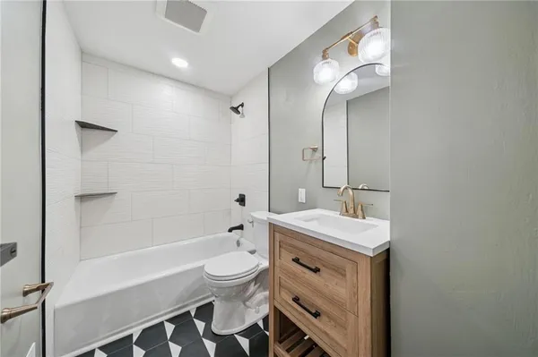 a bathroom with a sink a toilet a mirror and bathtub