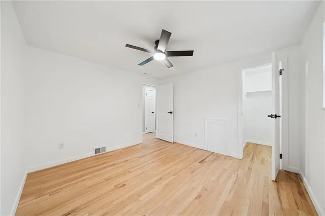 a view of a room with wooden floor and a ceiling fan