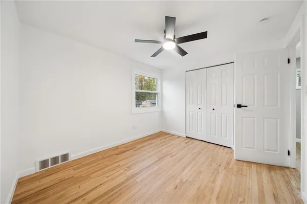 a view of empty room with wooden floor
