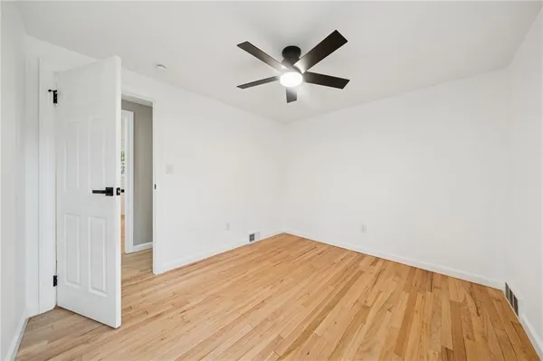 a view of empty room with wooden floor