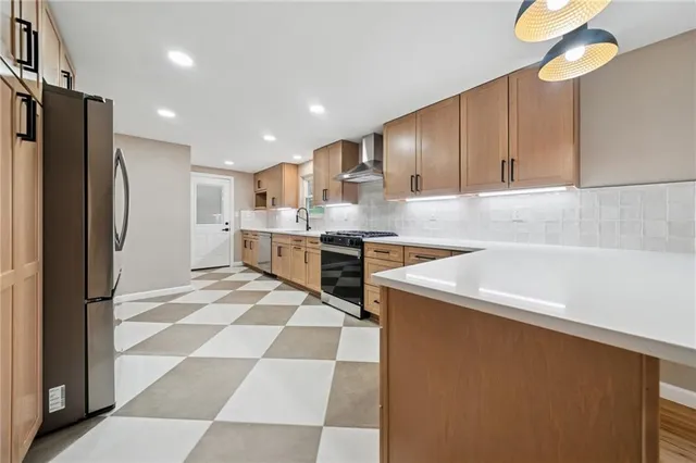 a kitchen with a sink a refrigerator and cabinets