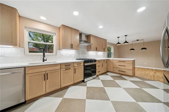 a kitchen with stainless steel appliances kitchen island granite countertop a sink and cabinets