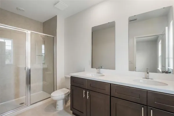 a bathroom with a sink toilet a mirror and shower