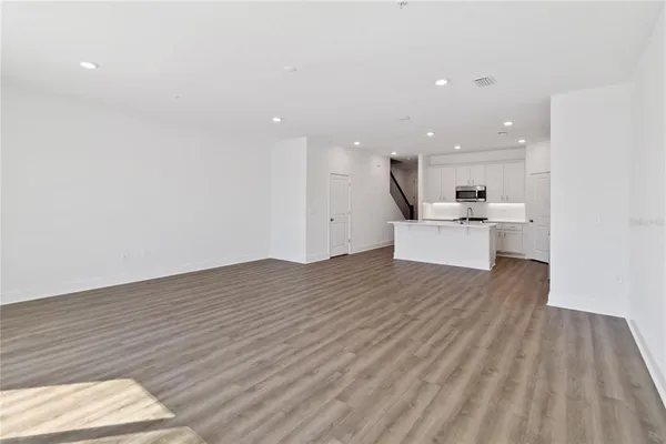 a view of kitchen with wooden floor and electronic appliances