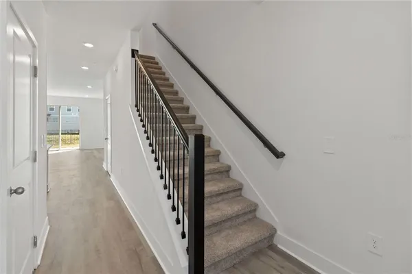 a view of staircase with white walls and railing