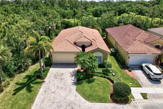 a aerial view of a house with a yard and large trees