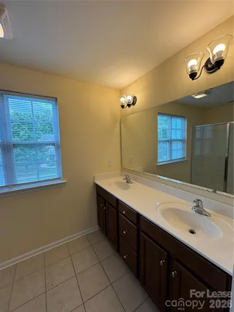 a bathroom with a double vanity sink a mirror and a bathtub