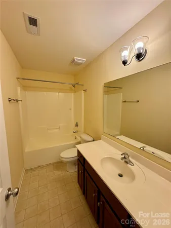 a bathroom with a double vanity sink a toilet and shower