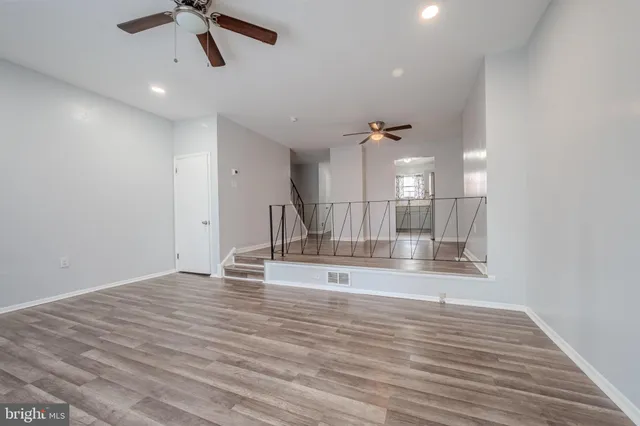 a view of a room with a ceiling fan wooden floor and a ceiling fan