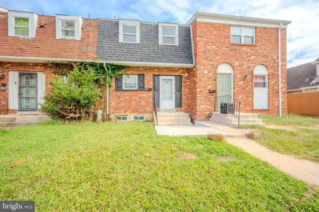front view of a brick house with a yard