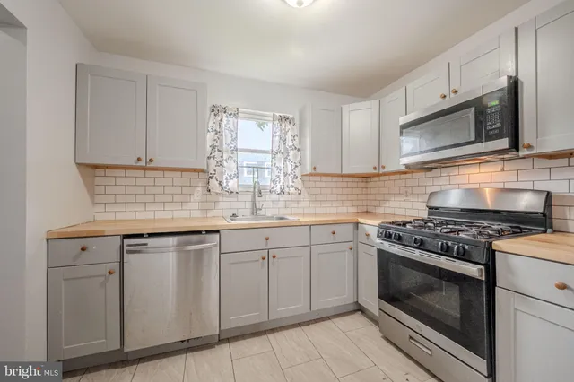 a kitchen with white cabinets appliances and sink
