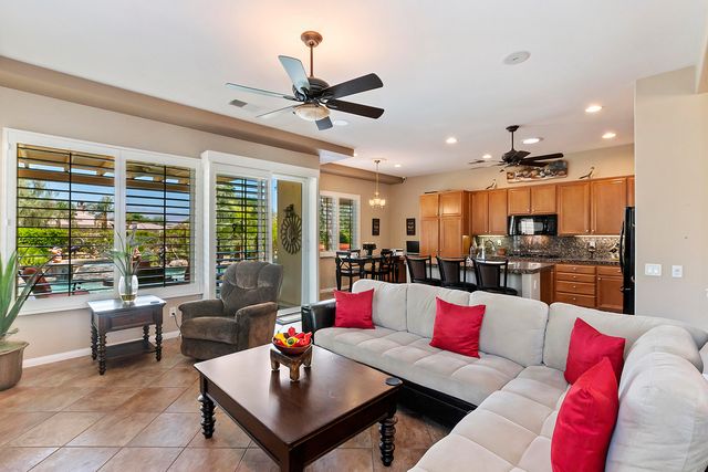 a living room with furniture kitchen view and large windows
