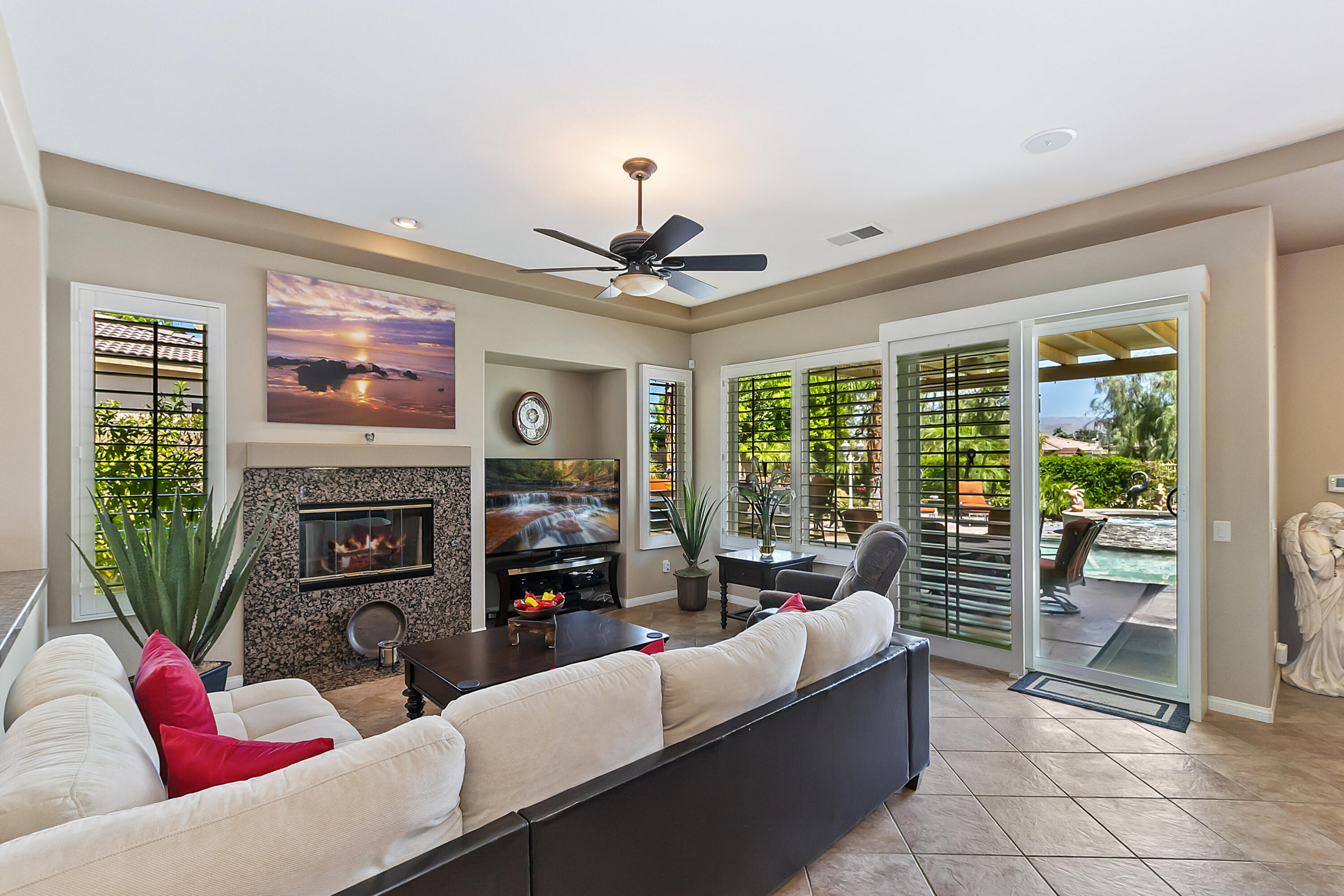 43328 Bordeaux Drive La Quinta, CA 92253 - Photo 16 of 38 a living room with furniture a fireplace and a flat screen tv