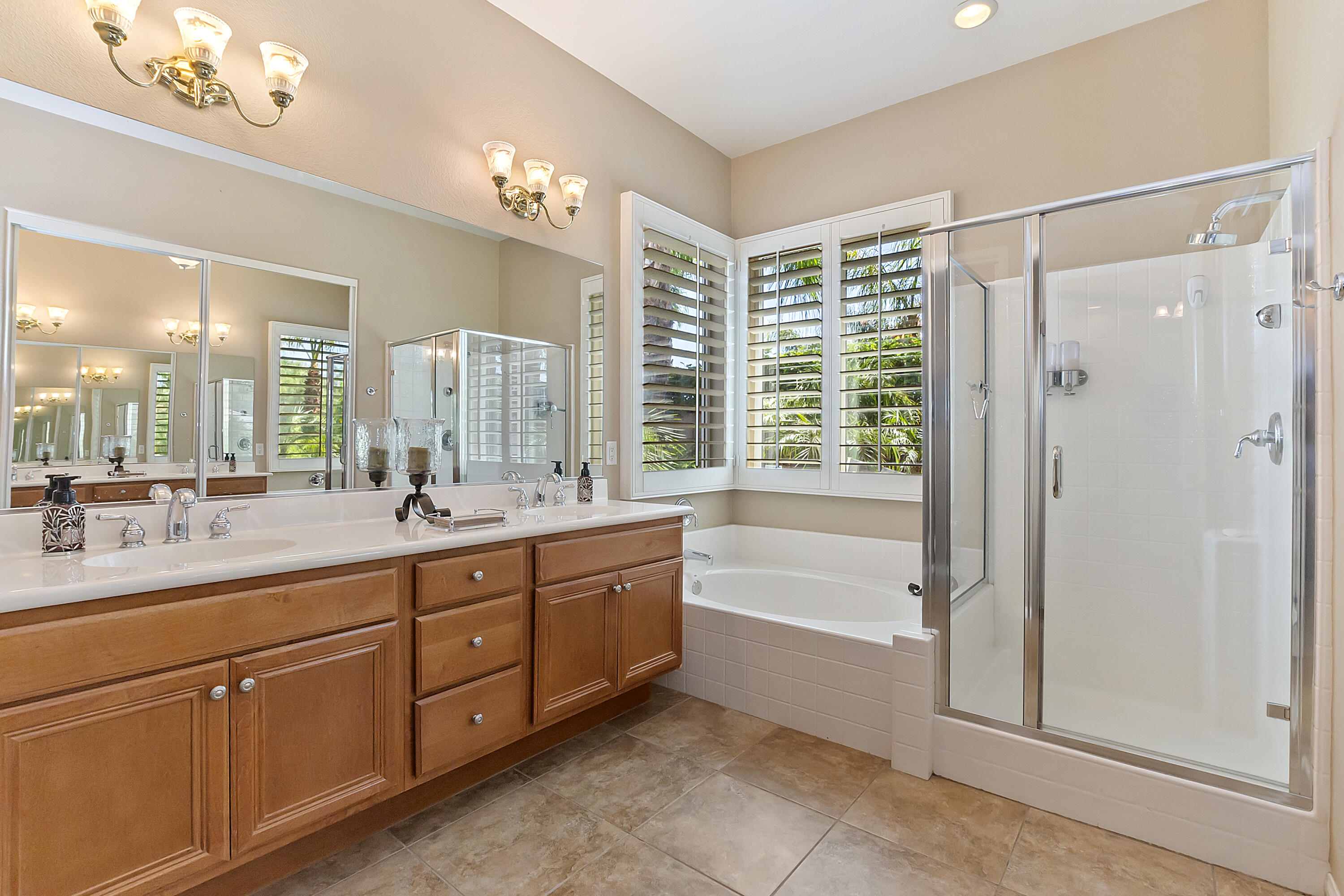 43328 Bordeaux Drive La Quinta, CA 92253 - Photo 25 of 38 a spacious bathroom with a double vanity sink a large mirror and a bathtub with shower