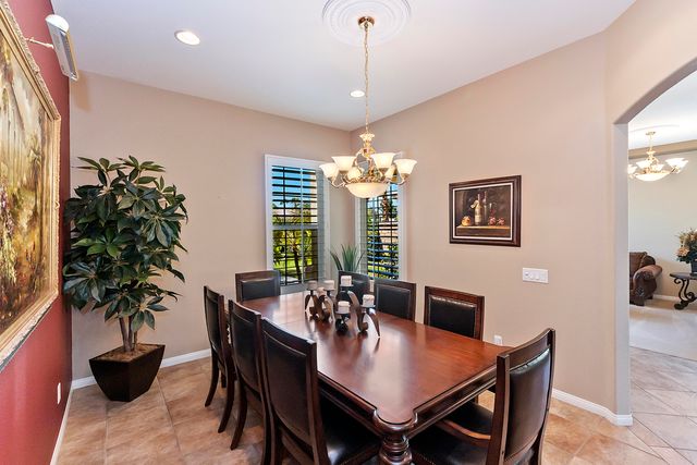 a dining room with furniture potted plants and wooden floor