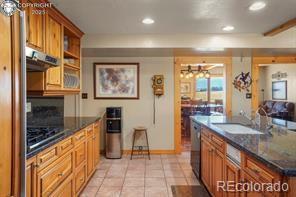6100 Waterbarrel Road Beulah, CO 81023 - Photo 11 of 50 a kitchen with stainless steel appliances granite countertop a refrigerator a stove and a sink with wooden floor