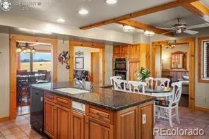 a kitchen with kitchen island granite countertop a table and chairs in it