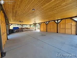 a view of swimming pool with outdoor seating and trees in the background