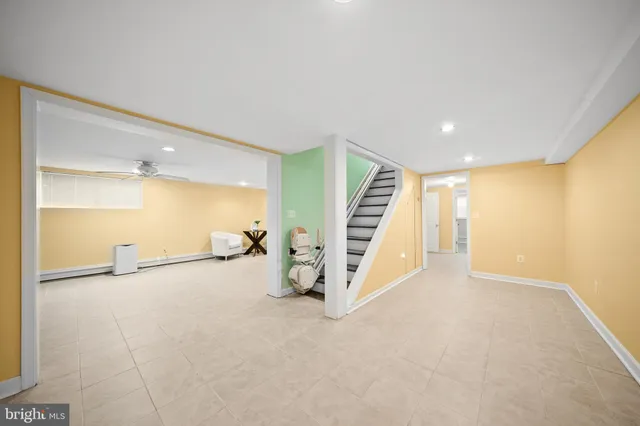 a view of an empty room with stairs and a living room