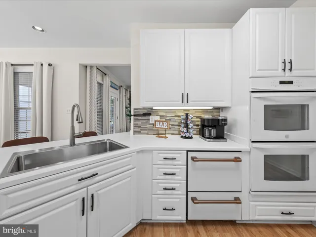 a kitchen with stainless steel appliances granite countertop a stove and white cabinets