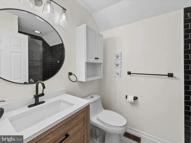 a bathroom with a sink a toilet and a mirror