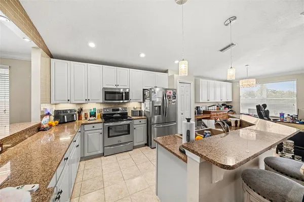 a kitchen with a sink a counter top stainless steel appliances and cabinets