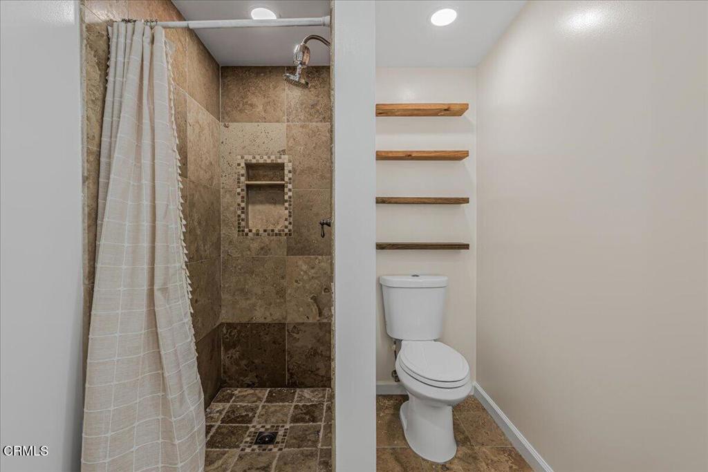 13902 Calvert Street Van Nuys, CA 91401 - Photo 20 of 33 a bathroom with a granite countertop shower a toilet and a sink