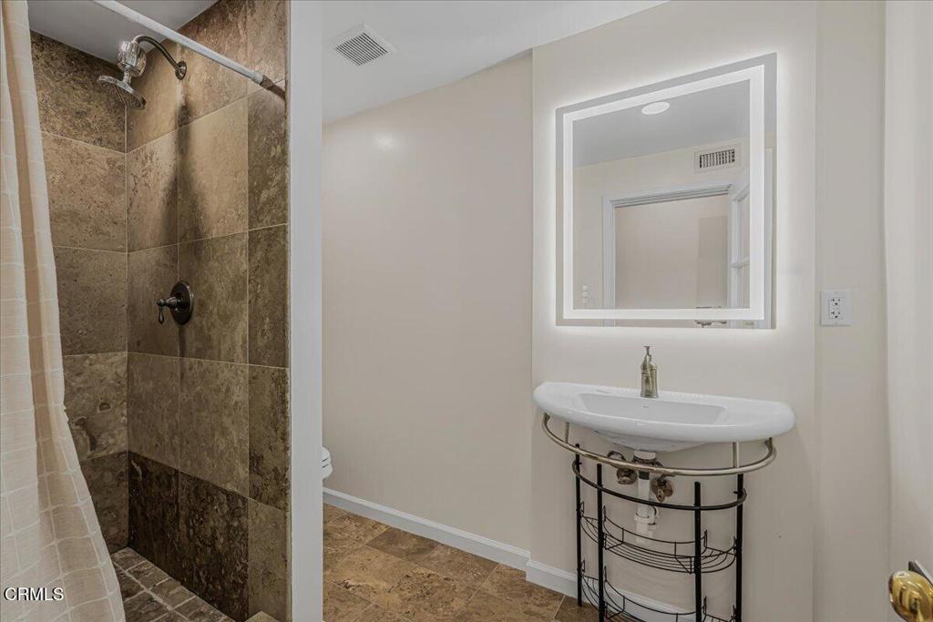 13902 Calvert Street Van Nuys, CA 91401 - Photo 21 of 33 a bathroom with a sink and a mirror