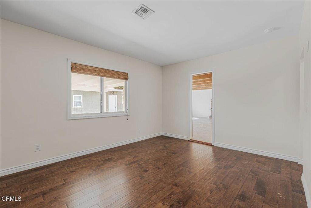 13902 Calvert Street Van Nuys, CA 91401 - Photo 22 of 33 an empty room with wooden floor and windows