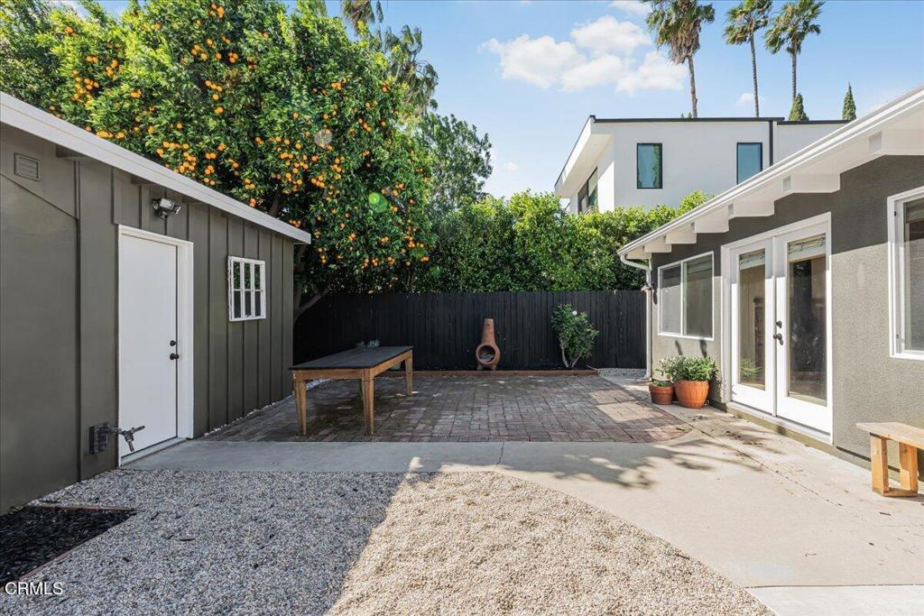 13902 Calvert Street Van Nuys, CA 91401 - Photo 28 of 33 a view of a patio with table and chairs with wooden fence and plants