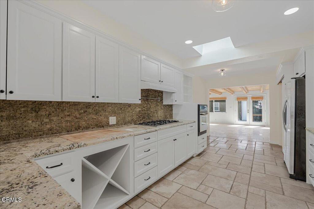 13902 Calvert Street Van Nuys, CA 91401 - Photo 8 of 33 a kitchen with granite countertop white cabinets and stainless steel appliances