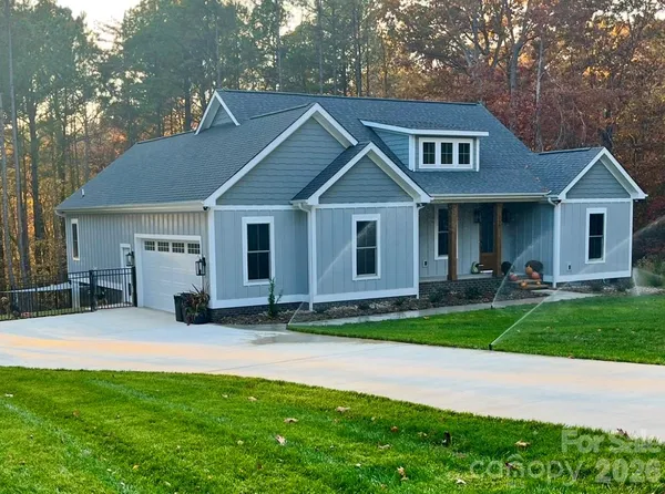 a front view of a house with a garden and trees