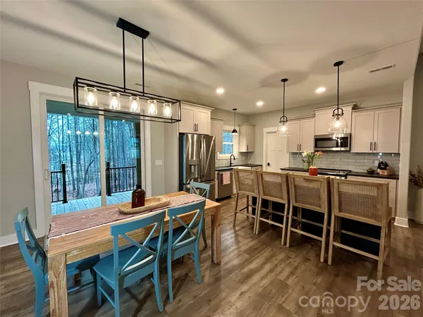 a kitchen with stainless steel appliances granite countertop a sink a stove and a wooden floors