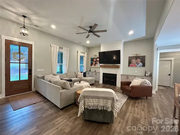 a living room with furniture a fireplace and a flat screen tv