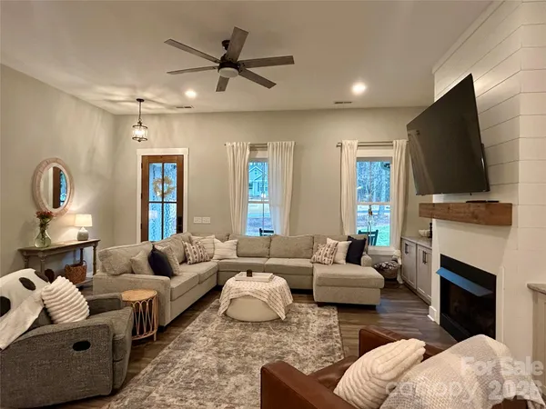 a living room with furniture a fireplace and a flat screen tv