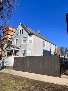 a view of a house with a wooden fence