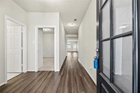 a view of a hallway with wooden floor and staircase