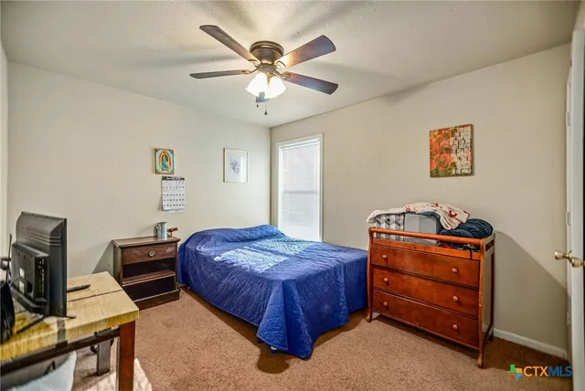 a bedroom with a bed and a ceiling fan
