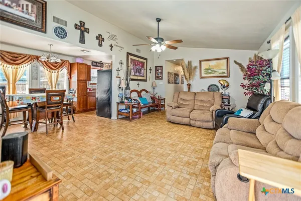 a living room with furniture a chandelier and a flat screen tv