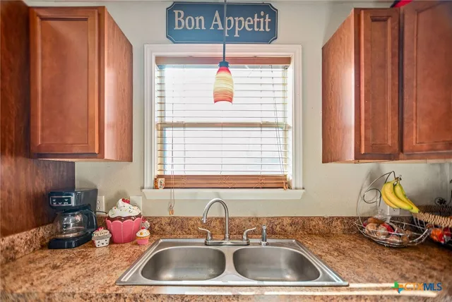 a kitchen with a sink window and cabinets