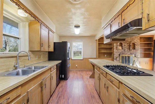 a kitchen with a refrigerator a stove and a sink