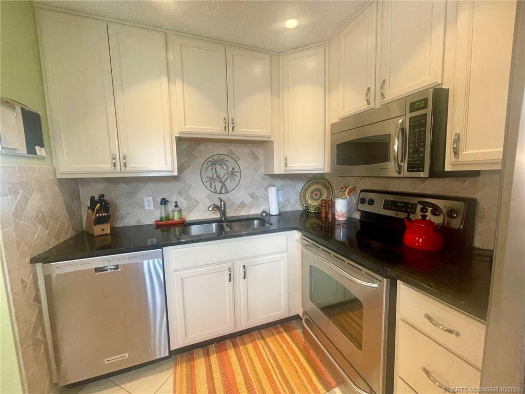 1225 Northwest 21st Street, Unit 3014 Stuart, FL 34994 - Photo 11 of 37 a kitchen with granite countertop a sink a stove and cabinets